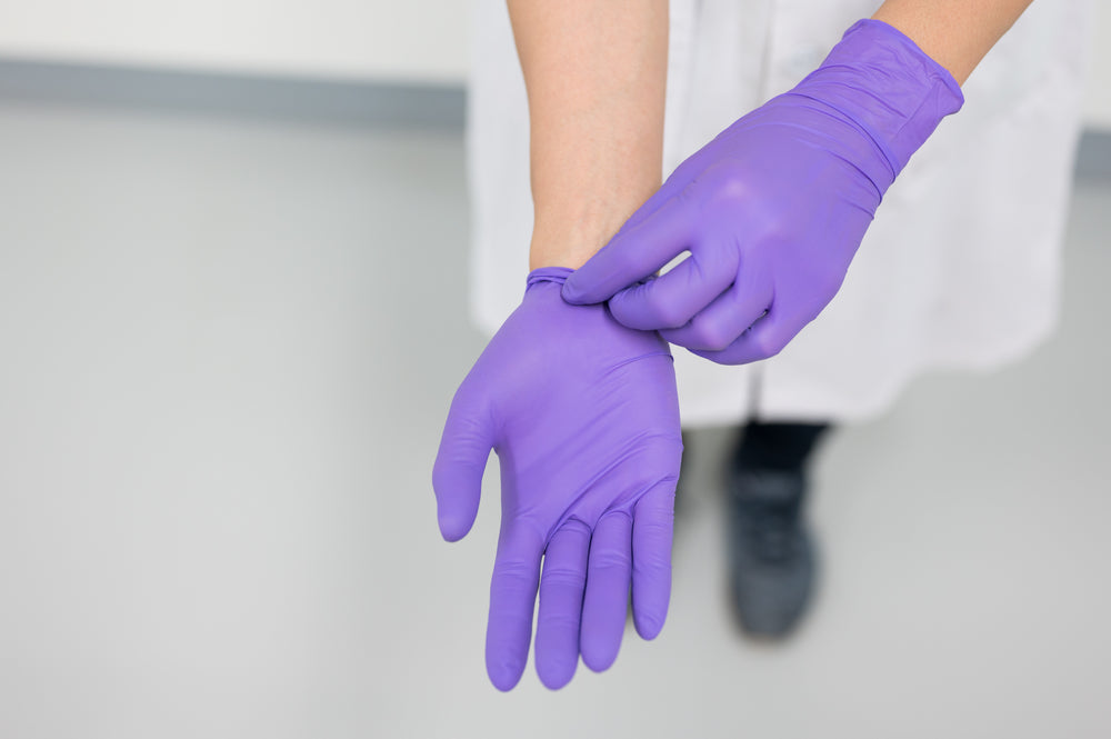 Health Professional Donning Purple Disposable Gloves for Safety and Hygiene in a Clinical Setting nitrile gloves for food service