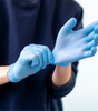 Person wearing light blue disposable nitrile gloves wholesale for protection and hygiene