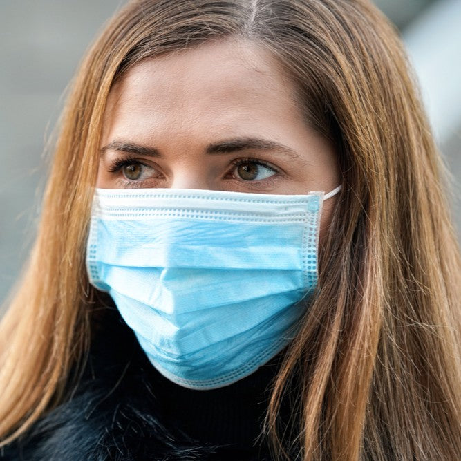 Woman wearing a blue medical-grade face mask wholesale for effective protection and safety