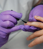 Purple nitrile gloves by CE Disposables used during a manicure for hygienic protection