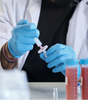 Laboratory technician using disposable nitrile gloves wholesale while handling medical syringes and vials