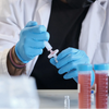 Laboratory technician using disposable nitrile gloves wholesale while handling medical syringes and vials