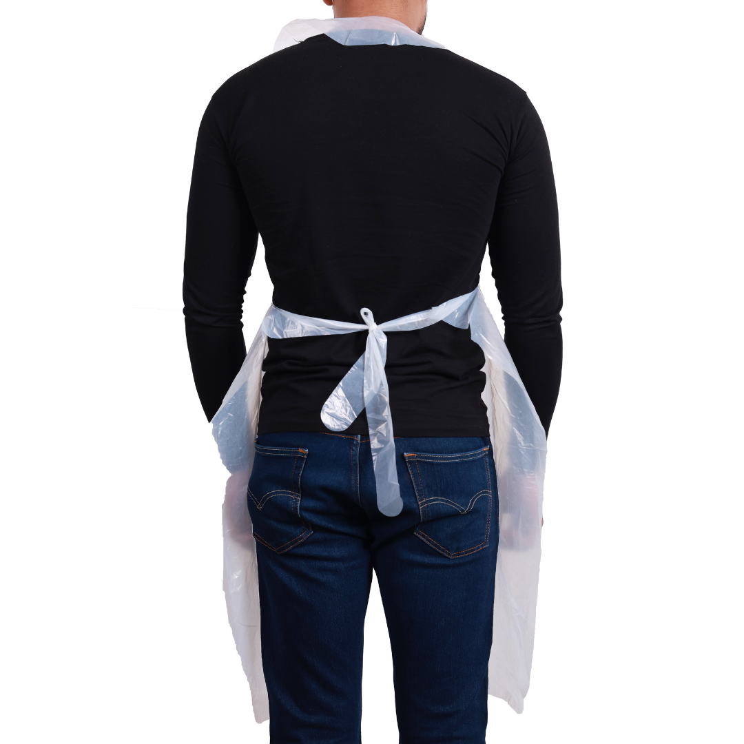 Man wearing clear disposable plastic aprons tied at the back for protection over black shirt and jeans